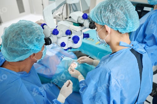 Preview: Medical worker and assistant doing laser vision correction operation
