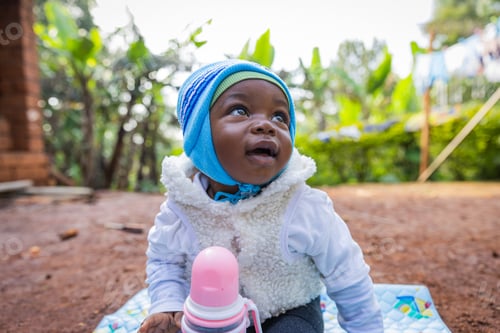 Preview: Cute and gorgeous African baby boy looking smilingly at the sky