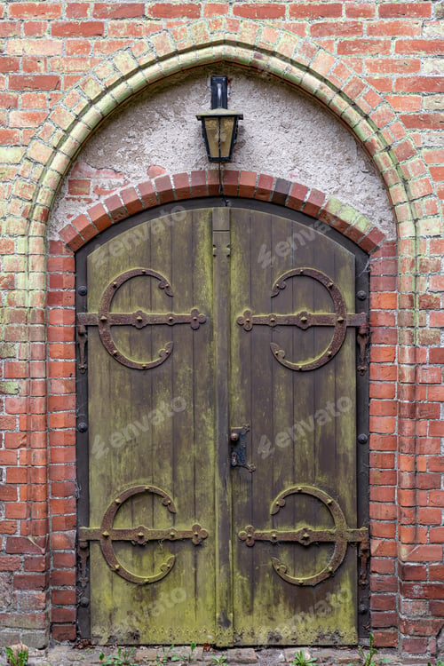 Preview: Vintage wooden door. Rusty wrought hinges. Gothic entry arch.