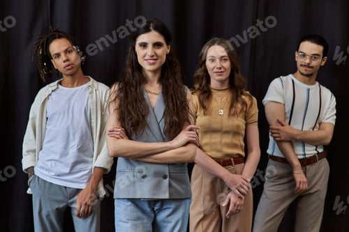 Preview: portrait of happy female team lead with folded arms near multiethnic team on black in office