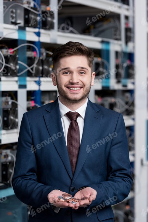 Preview: happy young businessman with heap of bitcoins in hands at cryptocurrency mining farm