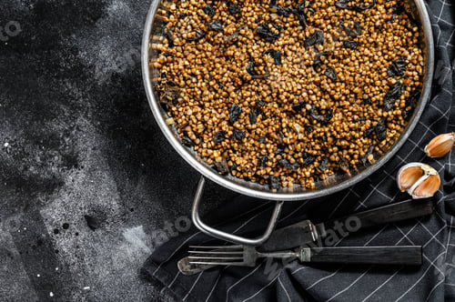 Preview: buckwheat porridge with field mushrooms and onion. Black background. Top view