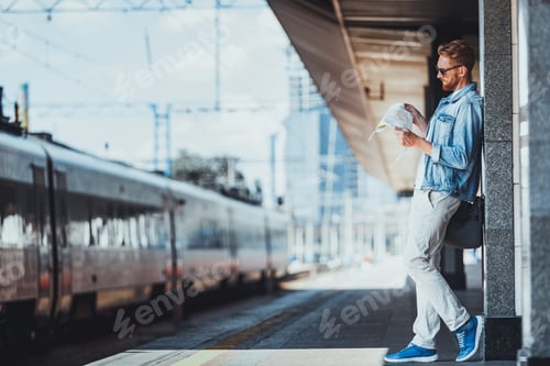Preview: Full Length Of A Pleasant Young Man Standing On The Platform While Planning His Route