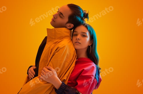 Preview: Teen couple in stylish clothes embracing in studio