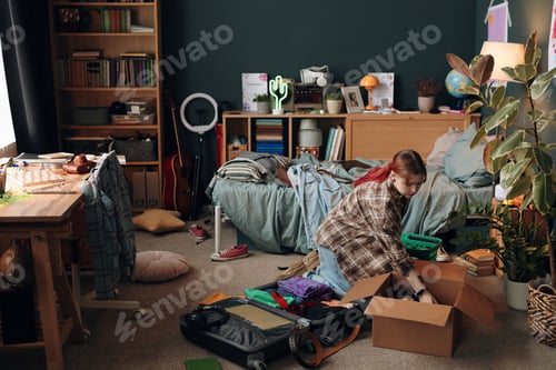 Preview: Caucasian Teenage Girl Packing Belongings in Bedroom While Organizing Room