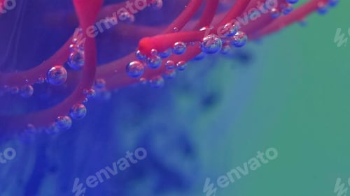 Preview: Bright background.Stock footage.The water is filled with purple paint and the paint gently falls on