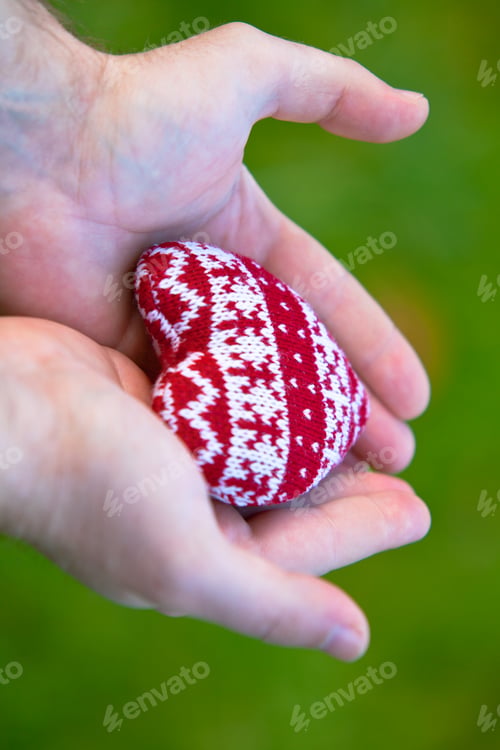 Preview: man hands with red knitted heart