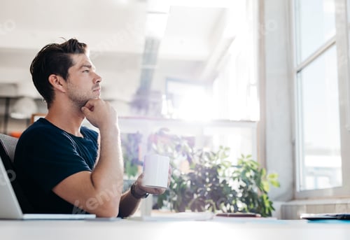 Preview: Businessman sitting in office and thinking