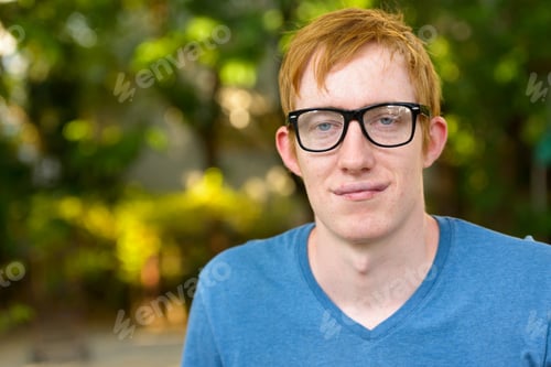 Preview: Face of nerd man with red hair wearing eyeglasses in the park
