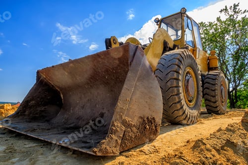 Preview: day view of a yellow excavator with a shovel at a construction site