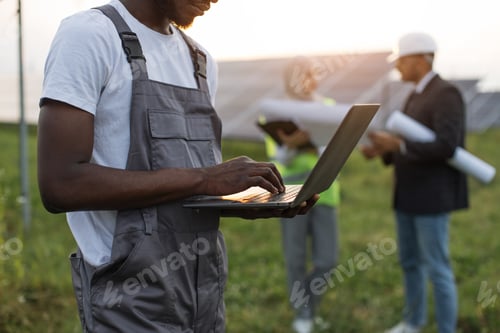 Preview: Close up of technician working on laptop at solar farm
