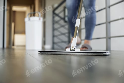 Preview: Woman mopping, wiping floor in modern home setting