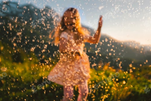 Preview: Out of focus girl dancing against the background of a flying dandelion in the mountains