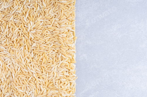 Preview: Heap of brown rice tidily arranged on marble background