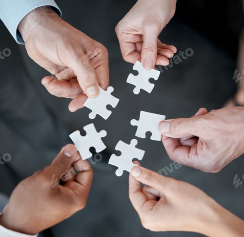 Preview: Cropped shot of five unrecognizable businesspeople building a puzzle in the office