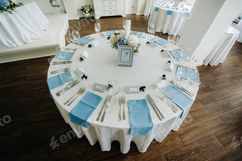 Preview: The festive table is decorated in light colors with blue napkins and flowers without food