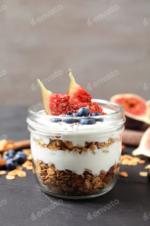 Preview: Tasty homemade granola dessert on dark grey table. Healthy breakfast