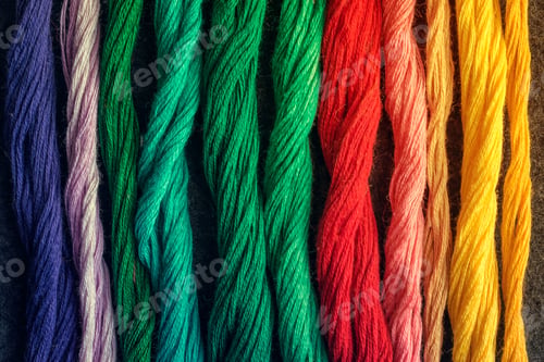 Preview: Bright multicolored embroidery thread yarns. Skeins of multicolored embroidery threads on dark felt