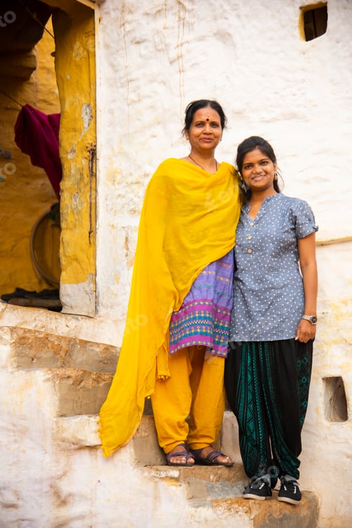 Preview: Women in front of white color traditional house, India.
