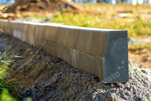 Preview: Concrete curb installation works at road construction site. Shallow DOF.