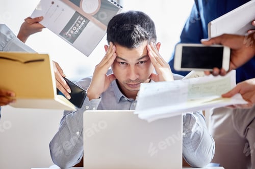 Preview: Shot of a young businessman looking stressed out in a demanding office environment