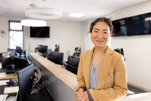 Preview: Happy asian businesswoman looking at camera in office