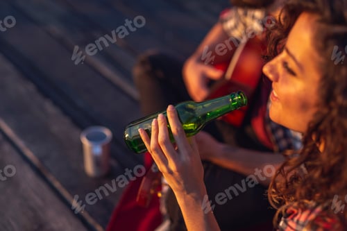 Preview: Couple playing the guitar and drinking beer