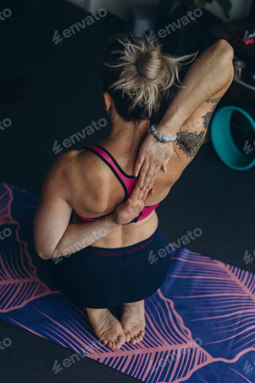 Preview: Attractive young woman practing yoga stretching yoga at home.