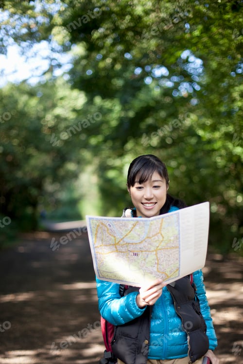 Preview: Young female hiker looking at map