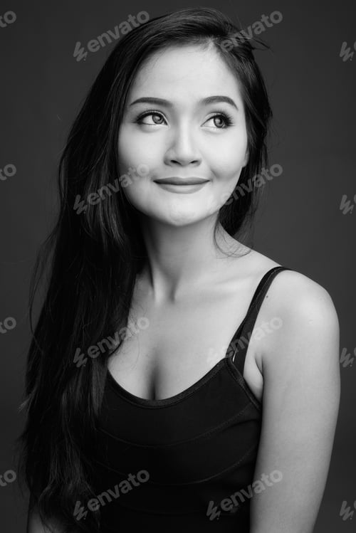 Preview: Young beautiful Asian woman against gray background