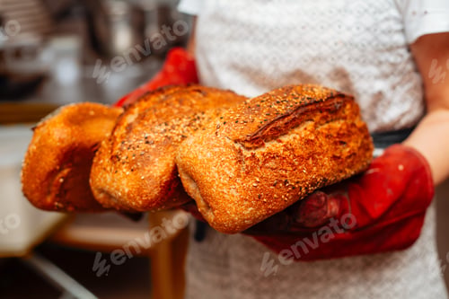 Preview: loaves of fresh bread in the baker's hands