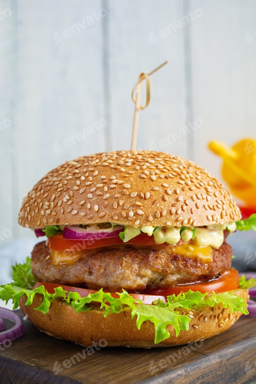 Preview: Homemade classic hamburger with beef cutlet, cheese, lettuce and tomato on wooden background