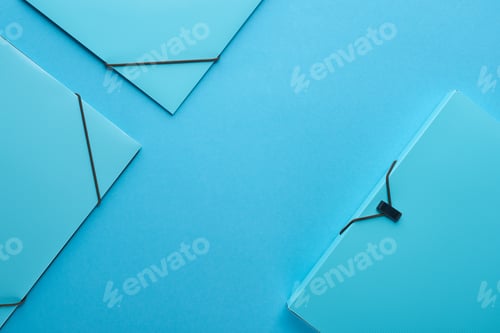 Preview: top view of paper binders isolated on blue with copy space