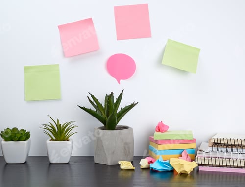 Preview: Stack of spiral notebooks and colored stickers, next to a ceramic pot with a flower