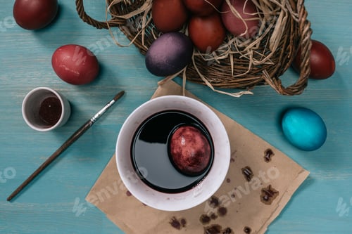 Preview: top view of cup with paint and easter egg on table