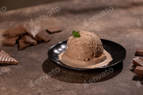 Preview: Scoop of chocolate ice cream with chocolate sprinkles on a black plate