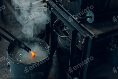 Preview: Blacksmith forges and tempering metal horseshoe in jar with water at forge.