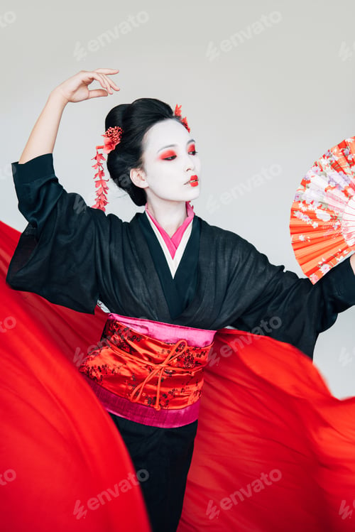 Preview: geisha in black kimono with hand fan and red cloth on background dancing isolated on white