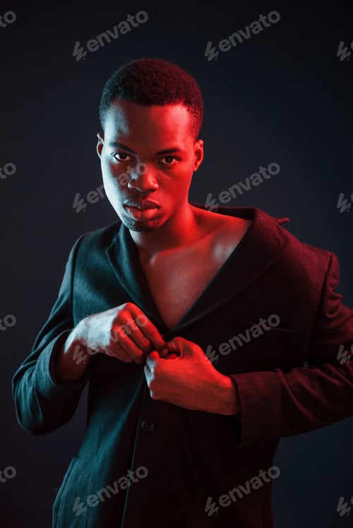 Preview: Confident and serious. Futuristic neon lighting. Young african american man in the studio