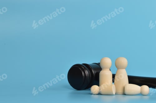 Preview: Wooden doll figures with judge gavel. Warning against the increasing risk of child abuse.