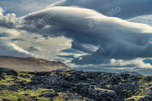 Preview: Dramatic clouds over volcanic landscape.