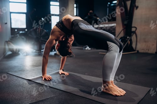 Preview: Slim athletic woman doing exercise bridge at gym