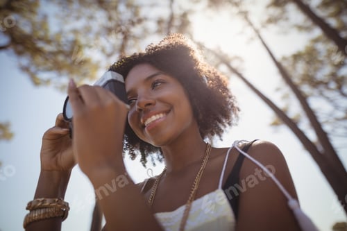 Preview: Low angle view of woman photographing