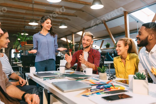 Preview: Group of designers discussing affairs, working in modern office