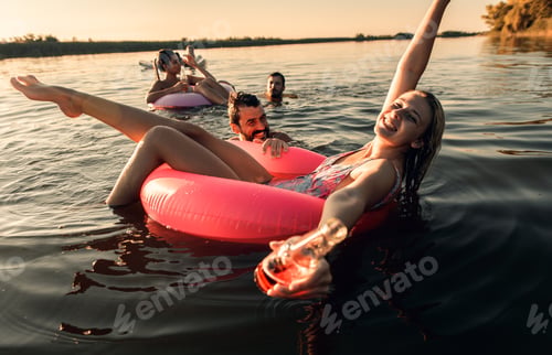 Preview: Group of friends enjoying a summer day swimming at the lake.