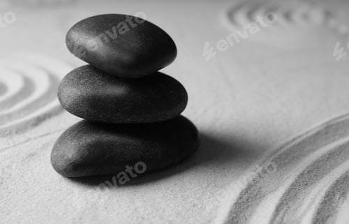 Preview: Stacked zen garden stones on sand with pattern, space for text. Meditation and harmony