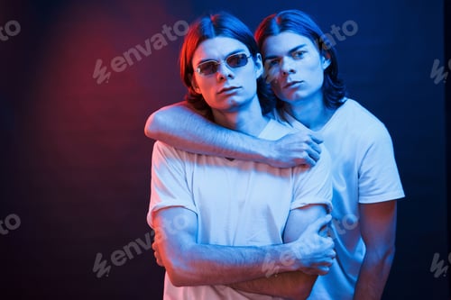 Preview: Family photo. Portrait of twin brothers. Studio shot in dark studio with neon light
