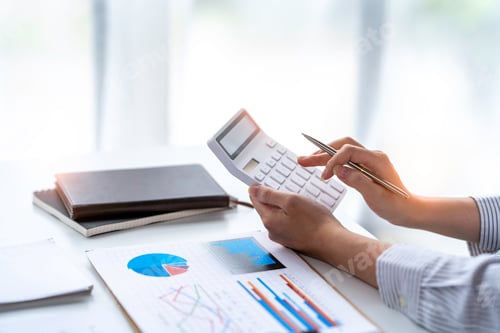 Preview: crop shot of business woman checks her work and uses a calculator to calculate her annual financial