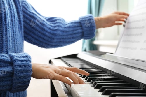 Preview: Young woman playing piano at home, closeup