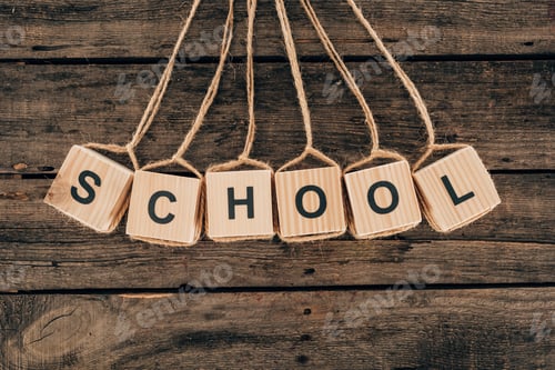 Preview: Top view of alphabet cubes with word school on wooden background